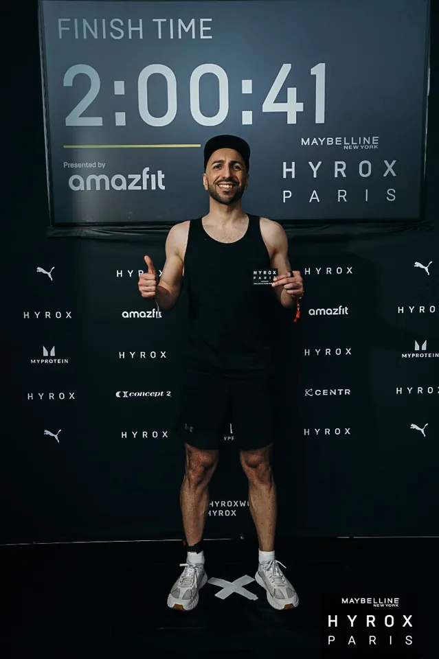 Onur à l'arrivée de Hyrox Paris, devant l'écran affichant 2:00:41